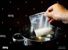 faire-bouillir-le-riz-dans-un-sachet-de-portions-un-sac-de-riz-blanc-cuit-est-tenu-avec-une-ma...jpg